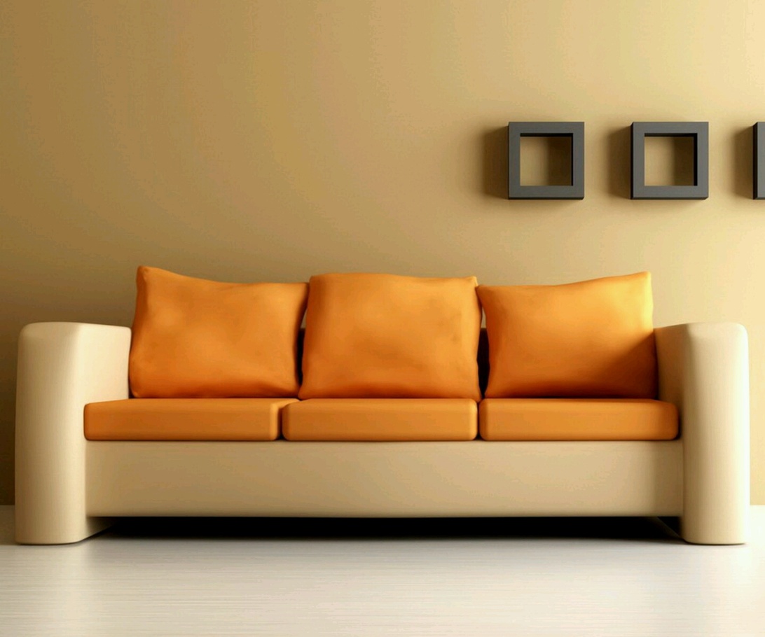 A contemporary sofa featuring a striking color combination with bright orange cushions and pillows contrasted against a cream/white frame. The minimalist design with clean lines is set against a neutral beige wall with simple decorative elements.
